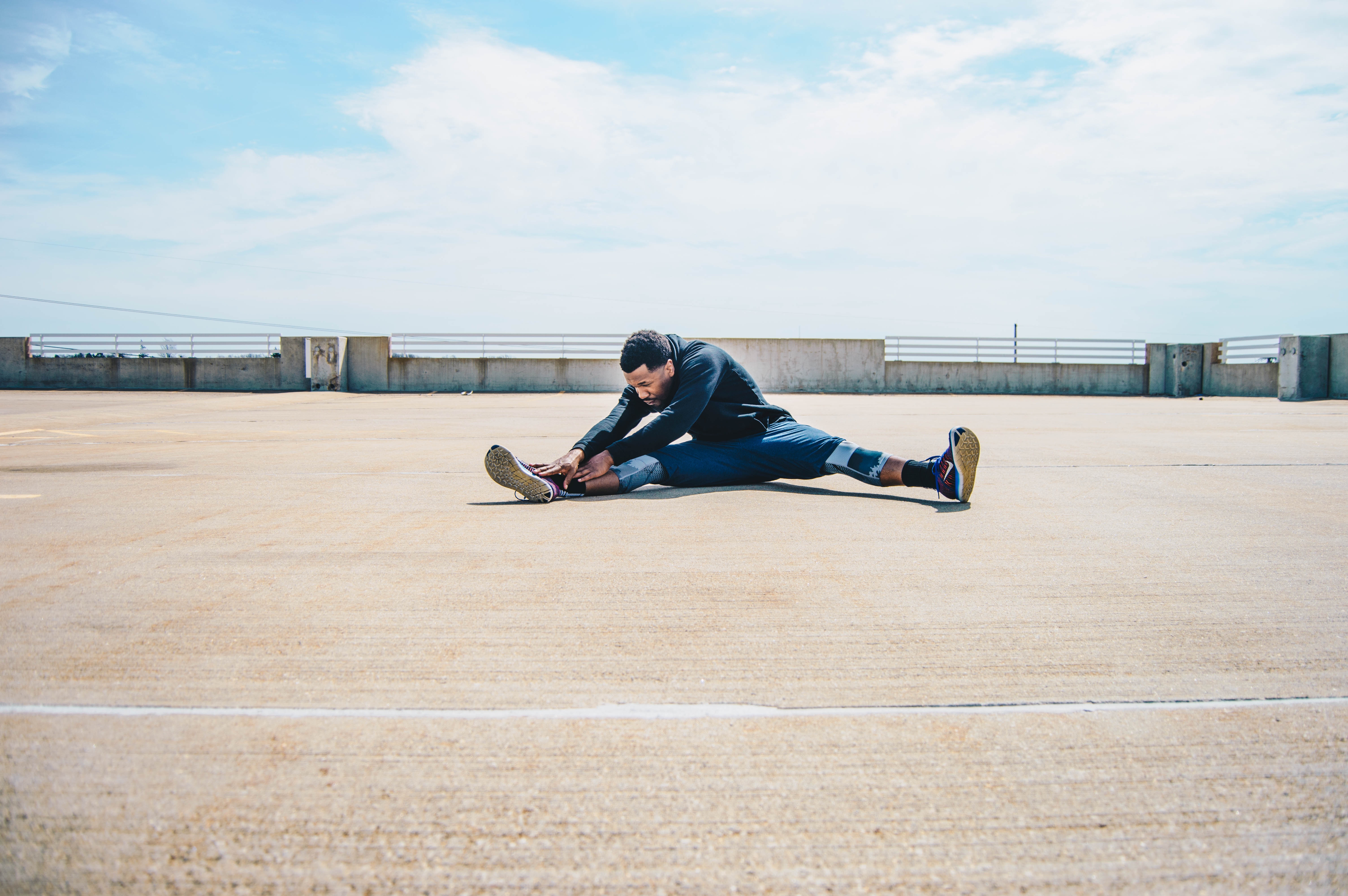 man stretching legs before a run